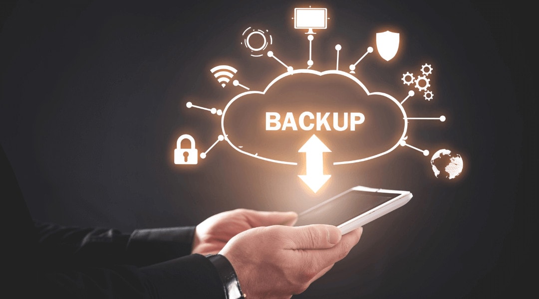 close up of a persons hands holding a tablet that shows transfer to a backup cloud.