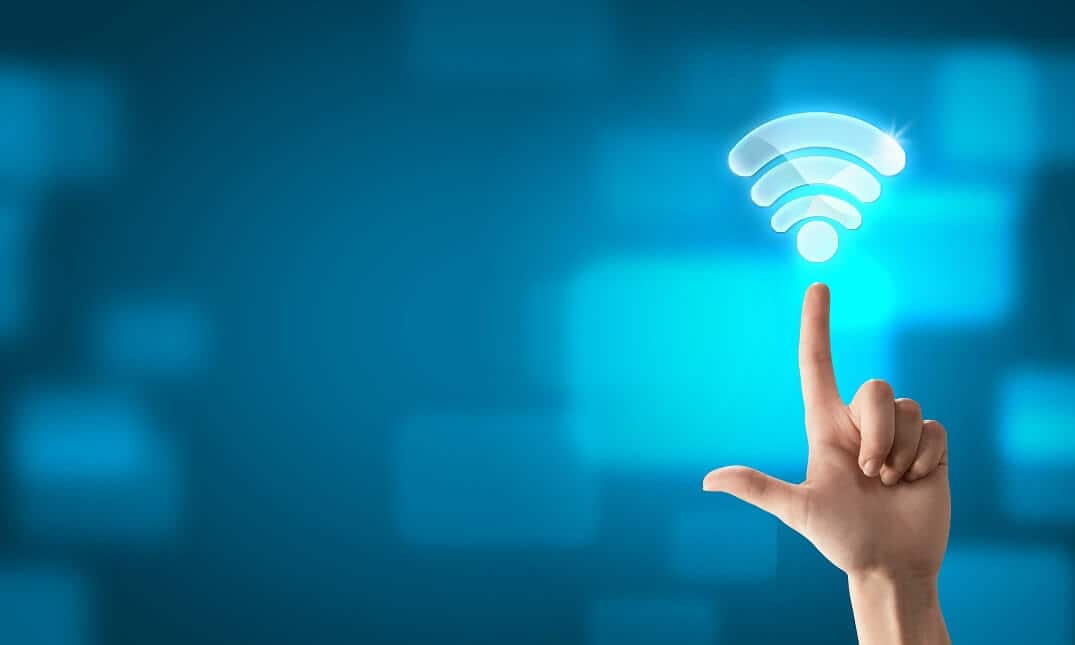 Finger on blue background pointing toward glowing white wifi symbol.