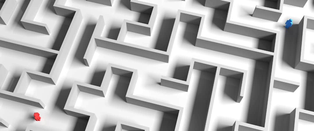 overhead shot of a maze with a blue person on one end and a red person on the other.