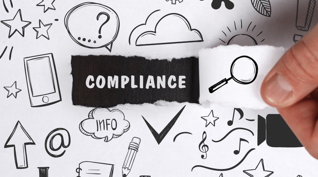 Hand pulls away piece of white paper uncovering the word "compliance"