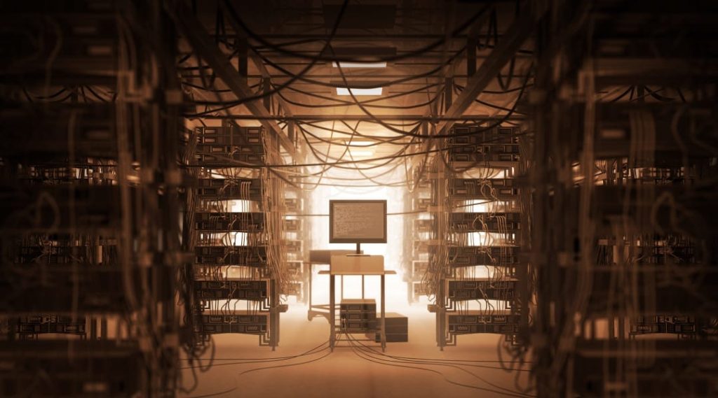 a single desktop monitor connected to and surrounded by rows of physical servers