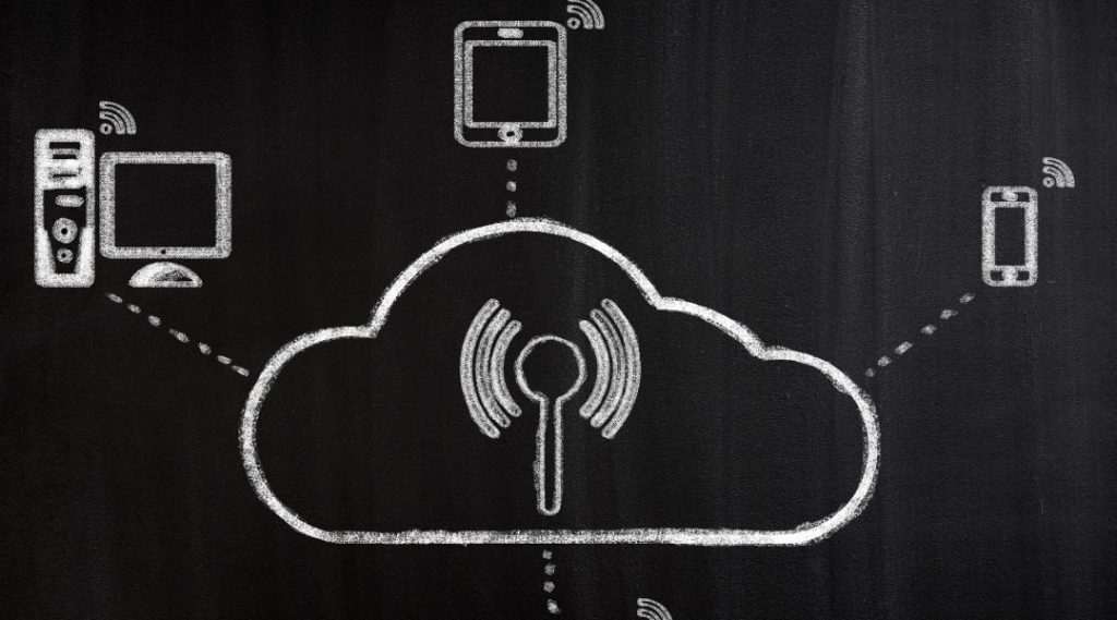 a cloud connecting to different devices drawn with white chalk on a chalk board.