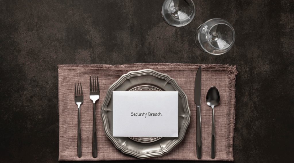 two glasses, in front of a silver table setting on a twine woven place mat set for "Security Breach"