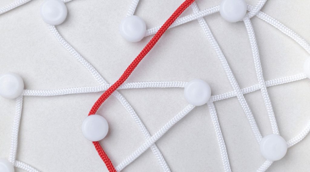 one red string amongst a few white strings connecting to and around different dots.