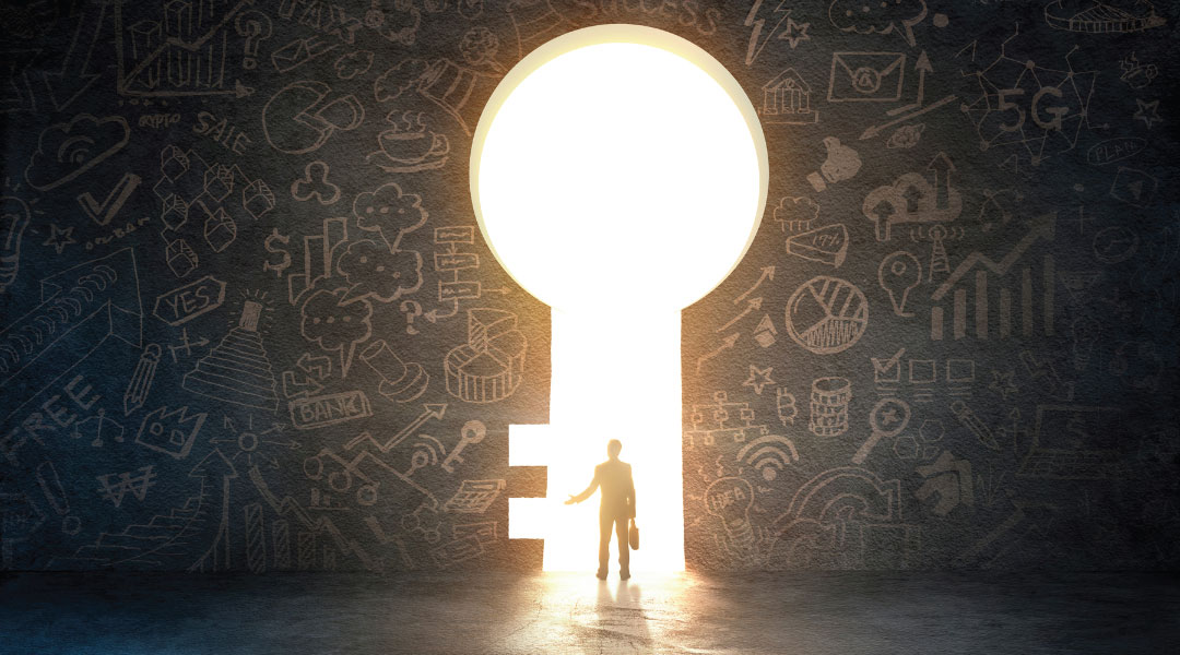 a professional individual standing in the well lit key shaped doorway of a wall that is graffitied with multiple different graphs and tech items.