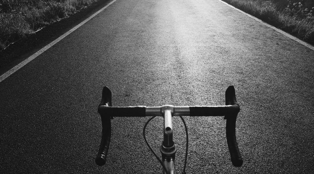 close up of bicycle handles with a road ahead