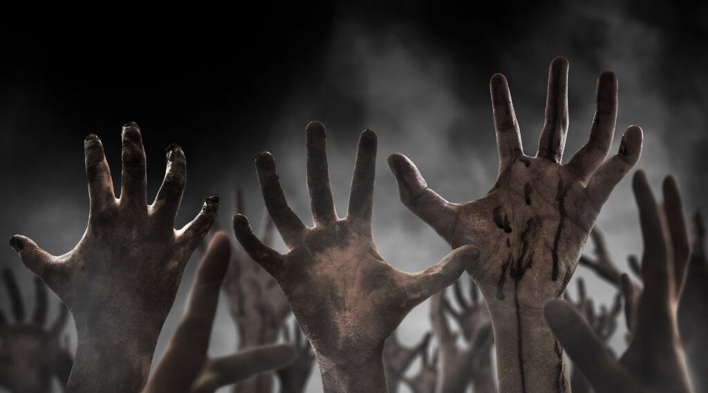 close up of zombie like hands reaching up in an airy mist.