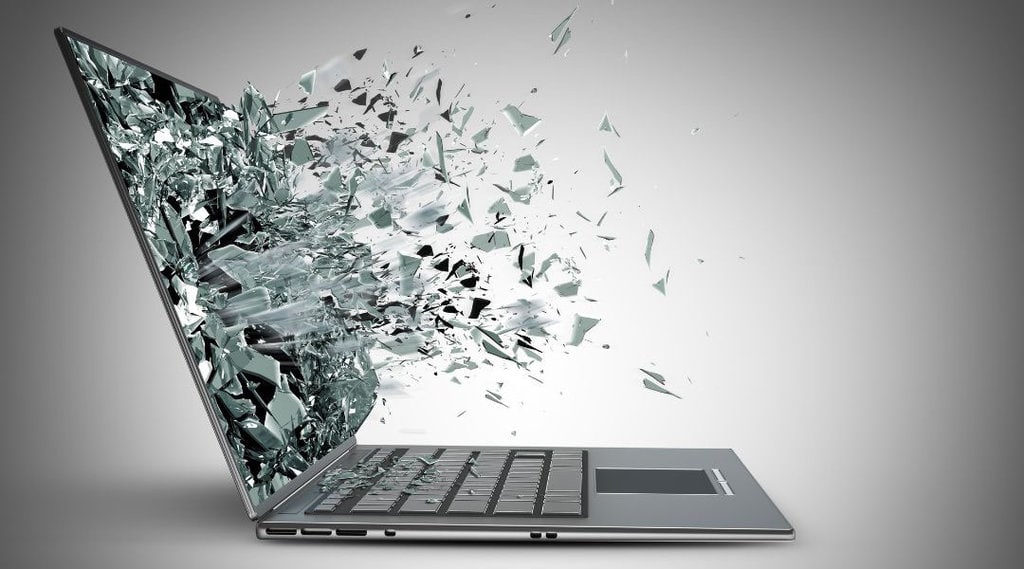 grey laptop screen erupting and shattering into many pieces.