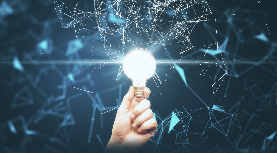 a hand holding a lit lightbulb that is surrounded by blue lines and nodes