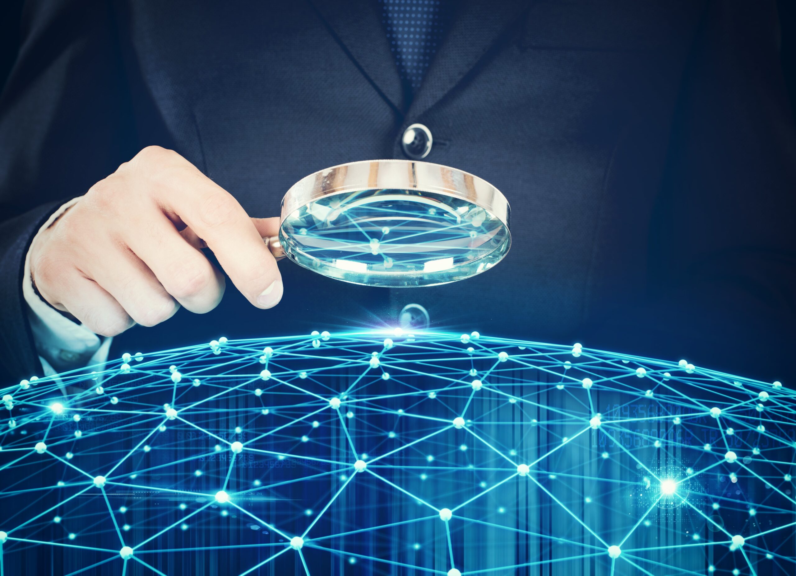 man with magnifying glass overlooking blue map