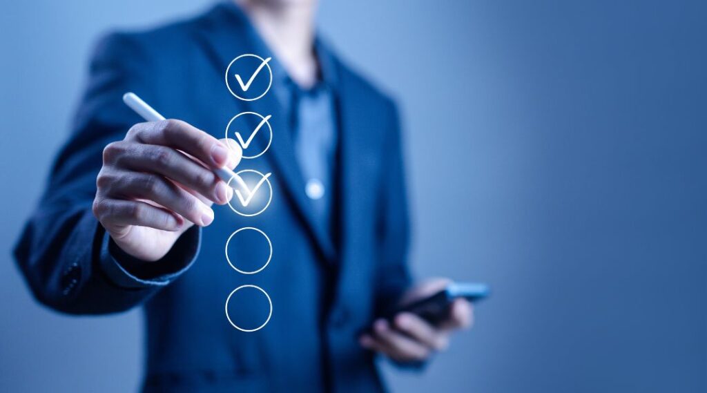 Business professional in a suit holding a digital pen and marking items on a virtual checklist with glowing checkmarks.